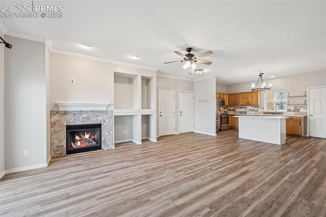4807 Kerry Lynn Vw Unit 102, Colorado Springs, CO 80922 - unfurnished living room featuring ceiling fan, light wood-style floors, baseboards, a stone fireplace, and a chandelier