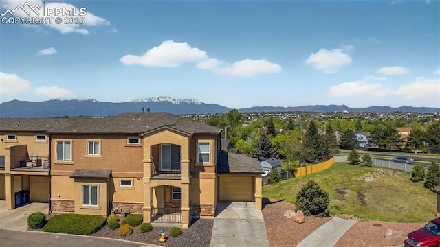 4807 Kerry Lynn Vw Unit 102, Colorado Springs, CO 80922 - view of front facade featuring a balcony, concrete driveway, stucco siding, stone siding, and a mountain view