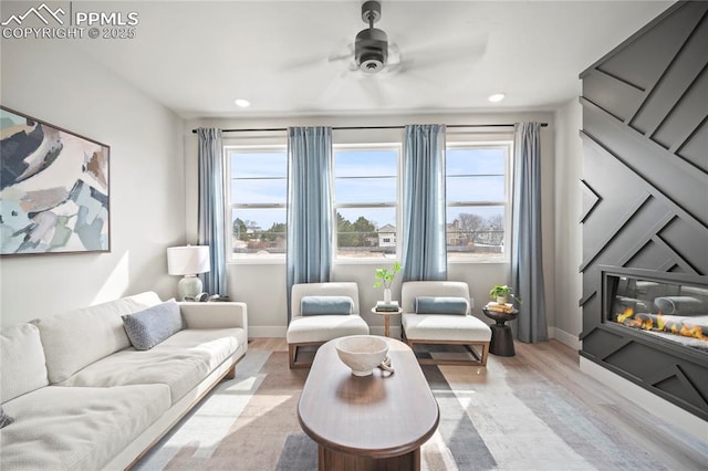 3077 Curly Grv, Colorado Springs, CO 80922 - living area featuring light wood-type flooring, baseboards, recessed lighting, ceiling fan, and a glass covered fireplace