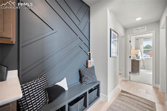 3071 Curly Grv, Colorado Springs, CO 80922 - mudroom with light wood-style flooring, baseboards, and a textured wall