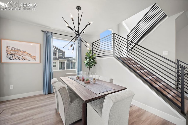 3071 Curly Grv, Colorado Springs, CO 80922 - dining space featuring a chandelier, stairs, light wood-style floors, and baseboards