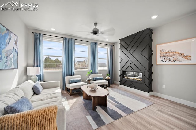 3071 Curly Grv, Colorado Springs, CO 80922 - living room featuring a ceiling fan, a large fireplace, light wood finished floors, healthy amount of natural light, and recessed lighting