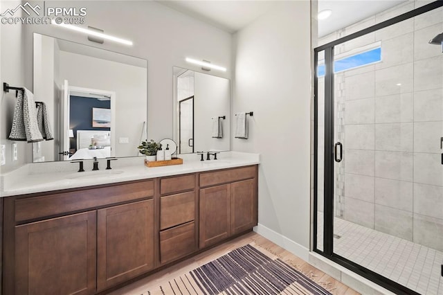 3071 Curly Grv, Colorado Springs, CO 80922 - bathroom featuring a shower stall, ensuite bathroom, double vanity, and wood finished floors