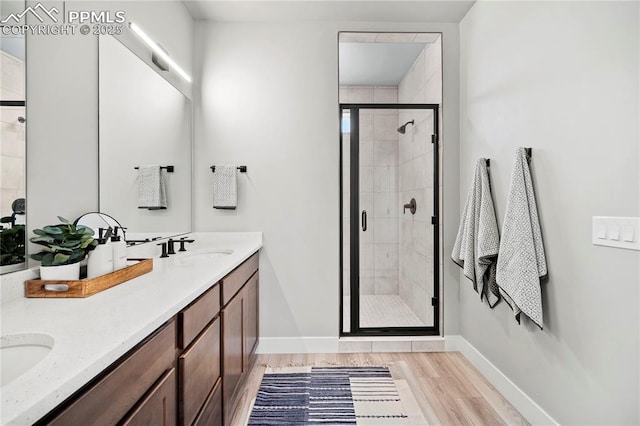 3071 Curly Grv, Colorado Springs, CO 80922 - bathroom featuring a shower stall, wood finished floors, baseboards, and double vanity