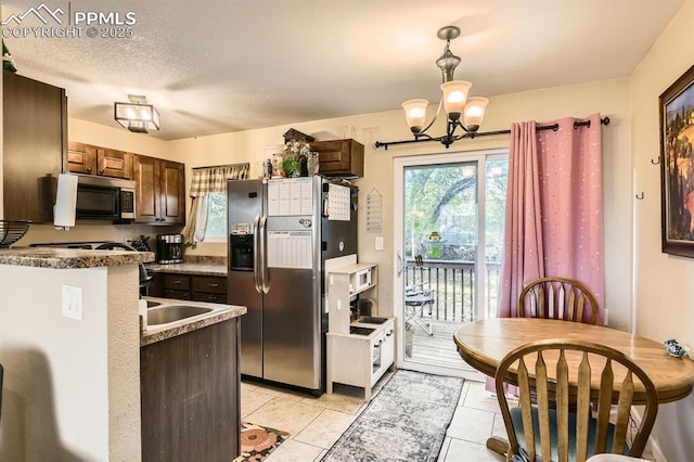 3566 Verde Dr, Colorado Springs, CO 80910 - kitchen with appliances with stainless steel finishes, a chandelier, light tile patterned flooring, pendant lighting, and dark brown cabinetry