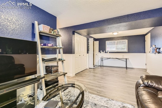 3566 Verde Dr, Colorado Springs, CO 80910 - living room featuring a textured wall, wood finished floors, baseboards, and a textured ceiling