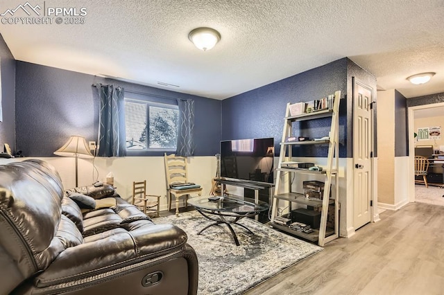 3566 Verde Dr, Colorado Springs, CO 80910 - living room with a textured wall, a textured ceiling, wood finished floors, and baseboards