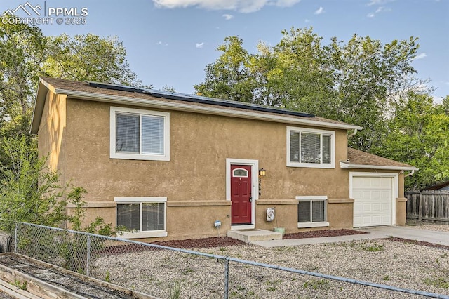 3566 Verde Dr, Colorado Springs, CO 80910 - raised ranch featuring stucco siding, concrete driveway, roof mounted solar panels, and central air condition unit