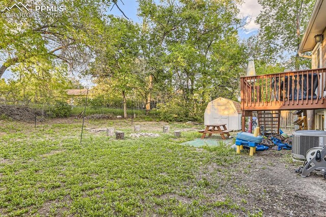 3566 Verde Dr, Colorado Springs, CO 80910 - view of yard with cooling unit, a wooden deck, and stairway