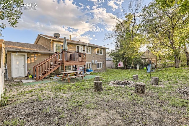 3566 Verde Dr, Colorado Springs, CO 80910 - back of house featuring stairs, a deck, a fire pit, a yard, and stucco siding