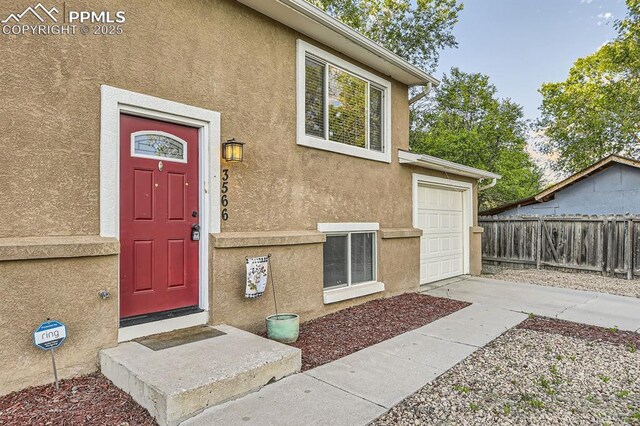 3566 Verde Dr, Colorado Springs, CO 80910 - doorway to property featuring stucco siding and driveway
