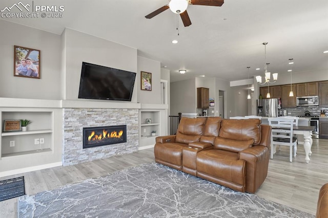 10192 Kentwood Dr, Colorado Springs, CO 80924 - living room with a ceiling fan, light wood finished floors, built in shelves, a chandelier, and recessed lighting