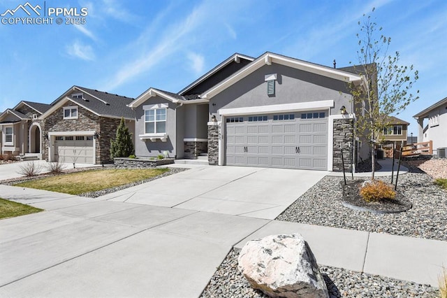 10192 Kentwood Dr, Colorado Springs, CO 80924 - view of front of home featuring stone siding, stucco siding, driveway, a garage, and central AC