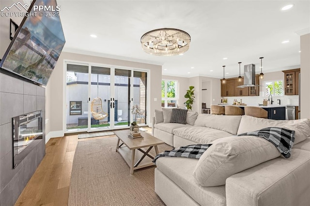 2625 Steele St, Denver, CO 80205 - living area featuring light wood-style flooring, recessed lighting, plenty of natural light, a tile fireplace, and a chandelier