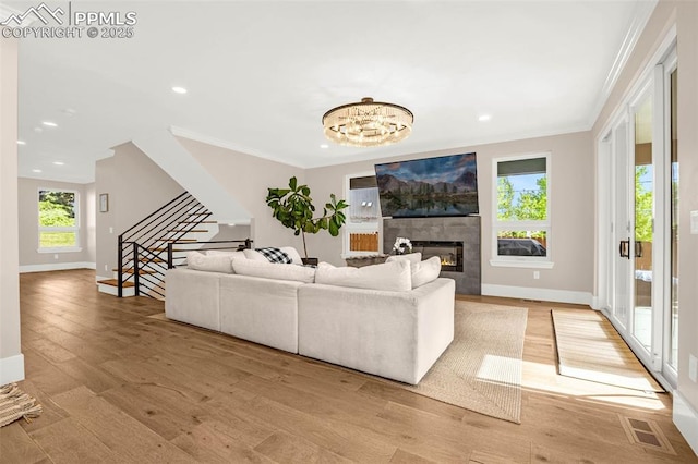 2625 Steele St, Denver, CO 80205 - living area with stairs, ornamental molding, baseboards, a tiled fireplace, and light wood finished floors