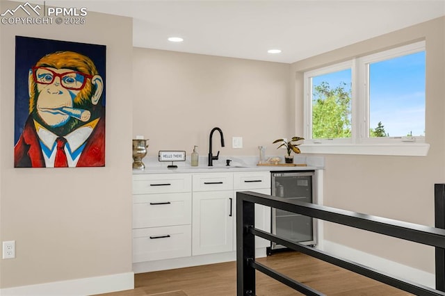 2625 Steele St, Denver, CO 80205 - indoor wet bar featuring beverage cooler, light wood finished floors, recessed lighting, and baseboards