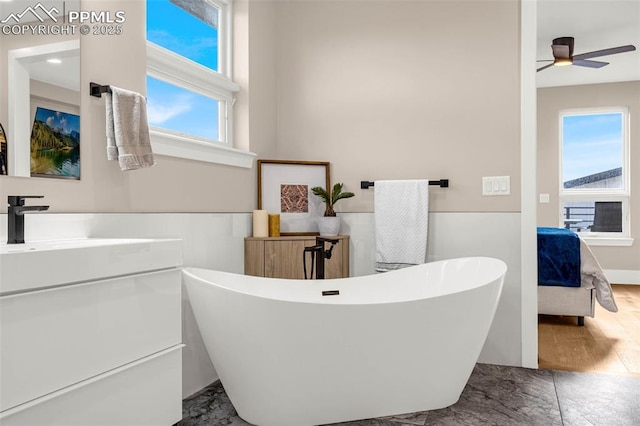 2625 Steele St, Denver, CO 80205 - ensuite bathroom with vanity, a soaking tub, ceiling fan, and wood finished floors