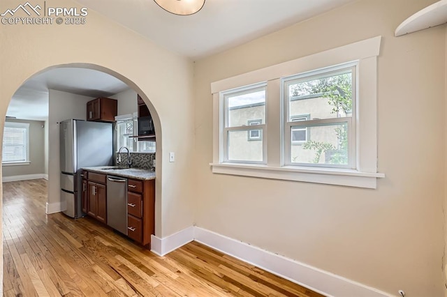 228 N Hancock Ave, Colorado Springs, CO 80903 - kitchen featuring appliances with stainless steel finishes, baseboards, light wood finished floors, and plenty of natural light