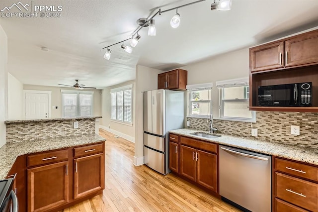 228 N Hancock Ave, Colorado Springs, CO 80903 - kitchen featuring appliances with stainless steel finishes, a sink, light wood finished floors, decorative backsplash, and a ceiling fan