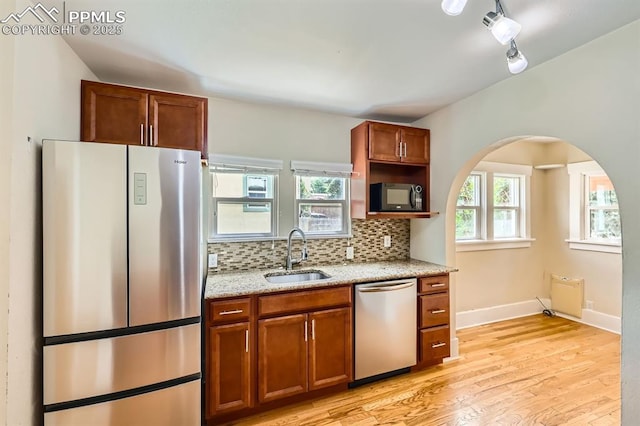 228 N Hancock Ave, Colorado Springs, CO 80903 - kitchen with appliances with stainless steel finishes, a sink, light wood-type flooring, tasteful backsplash, and light stone counters