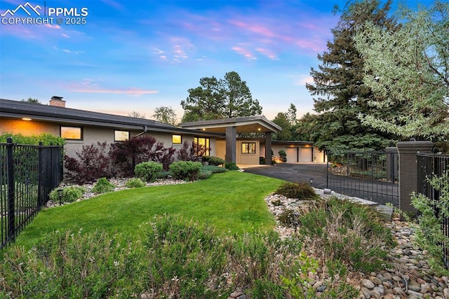 312 Lake Ave, Colorado Springs, CO 80906 - back of property at dusk featuring a garage, stucco siding, and a chimney