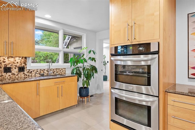 312 Lake Ave, Colorado Springs, CO 80906 - kitchen featuring stainless steel double oven, dark stone counters, a sink, backsplash, and light brown cabinets