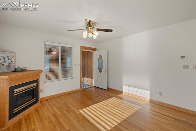 229 E Washington St, Colorado Springs, CO 80907 - unfurnished living room featuring light wood-style flooring, ceiling fan, a glass covered fireplace, and baseboards