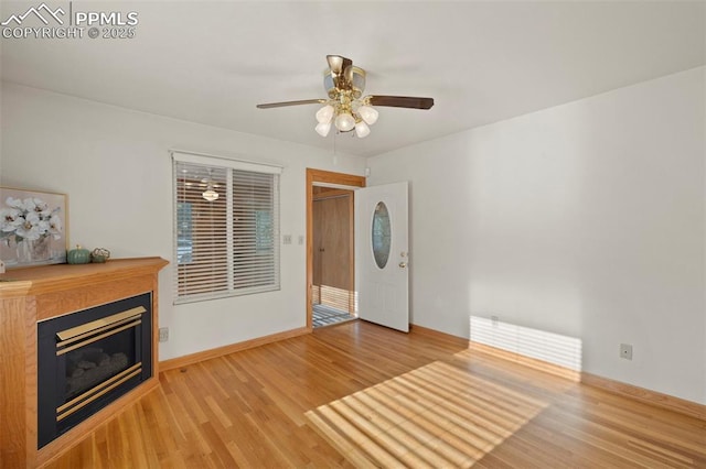 229 E Washington St, Colorado Springs, CO 80907 - unfurnished living room with wood finished floors, a ceiling fan, a glass covered fireplace, and baseboards