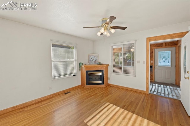 229 E Washington St, Colorado Springs, CO 80907 - unfurnished living room featuring healthy amount of natural light, a glass covered fireplace, and wood finished floors