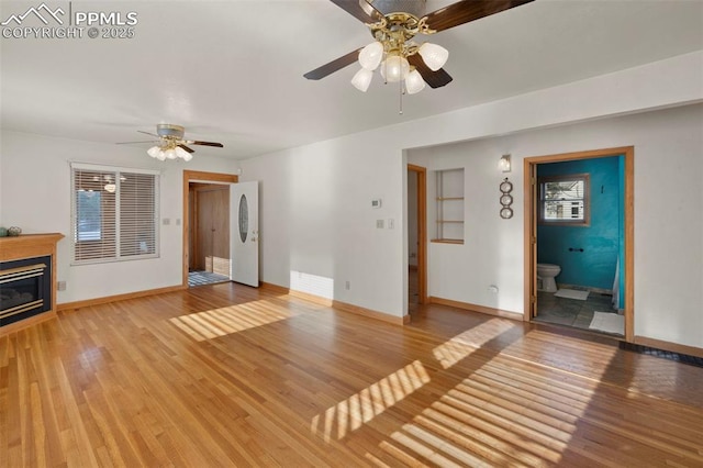 229 E Washington St, Colorado Springs, CO 80907 - unfurnished living room with a ceiling fan, light wood-style floors, baseboards, and a glass covered fireplace