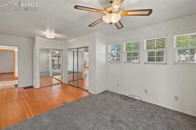 229 E Washington St, Colorado Springs, CO 80907 - unfurnished bedroom featuring two closets, baseboards, a ceiling fan, and wood finished floors