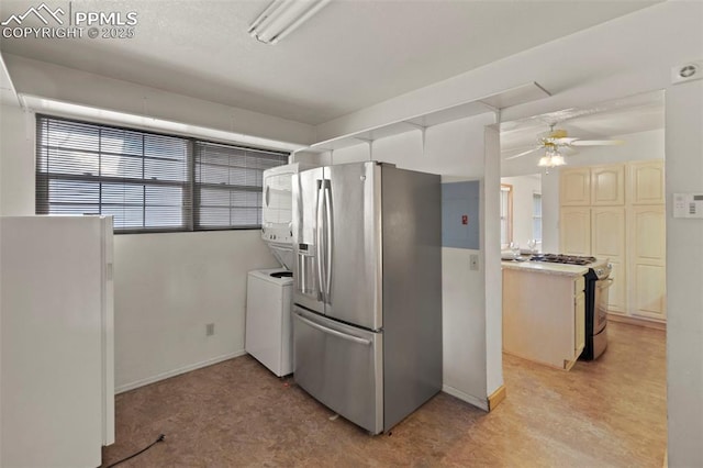 229 E Washington St, Colorado Springs, CO 80907 - kitchen featuring appliances with stainless steel finishes, a ceiling fan, light countertops, stacked washer / dryer, and baseboards