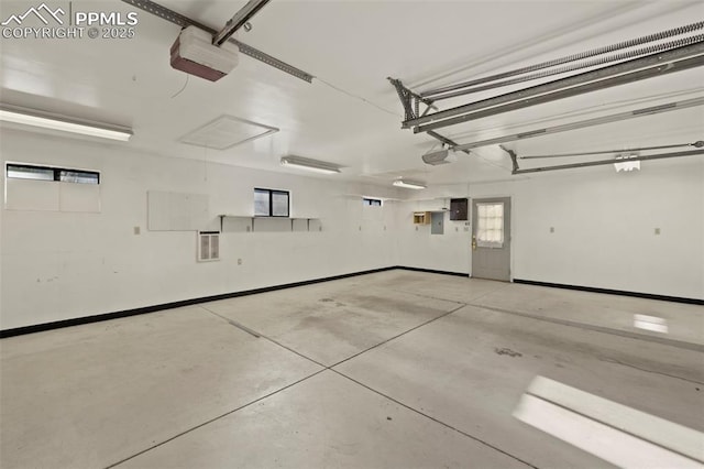 229 E Washington St, Colorado Springs, CO 80907 - garage featuring a garage door opener, baseboards, and electric panel