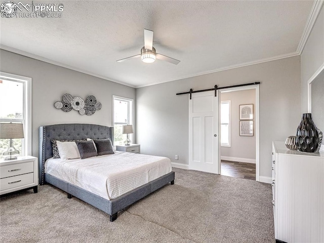 772 7th St, Penrose, CO 81240 - carpeted bedroom featuring a barn door, crown molding, baseboards, a ceiling fan, and a textured ceiling