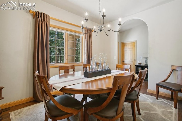 20190 Deer Shadow Way, Monument, CO 80132 - dining area with arched walkways, baseboards, light wood finished floors, and a chandelier