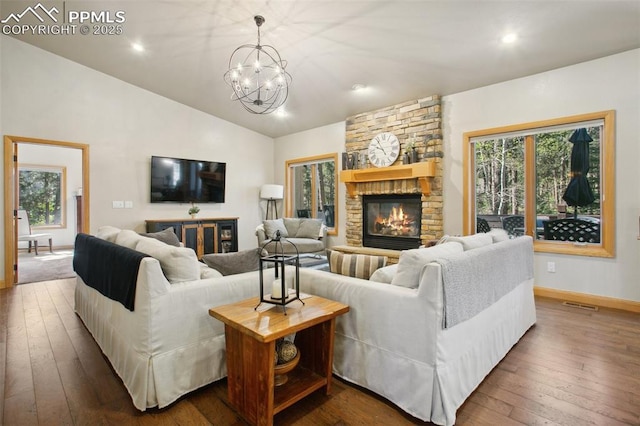 20190 Deer Shadow Way, Monument, CO 80132 - living area featuring a chandelier, dark wood-type flooring, a stone fireplace, lofted ceiling, and baseboards