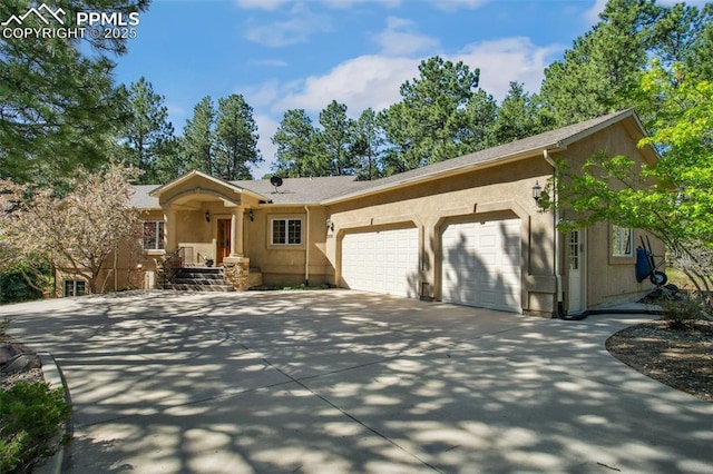20190 Deer Shadow Way, Monument, CO 80132 - view of front of property with an attached garage, concrete driveway, and stucco siding