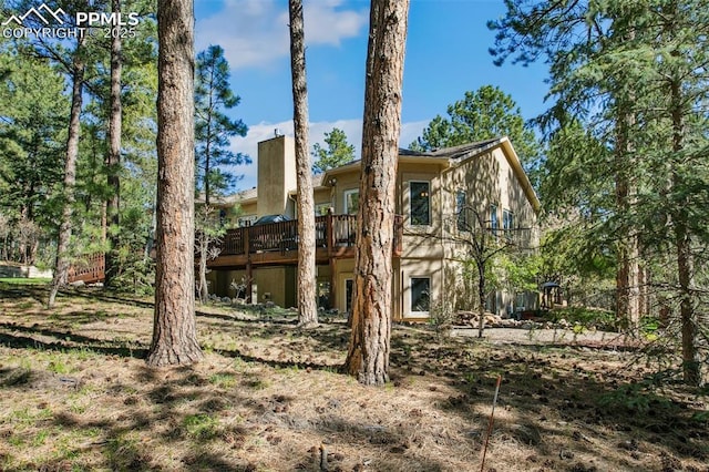 20190 Deer Shadow Way, Monument, CO 80132 - rear view of house with a wooden deck and a chimney