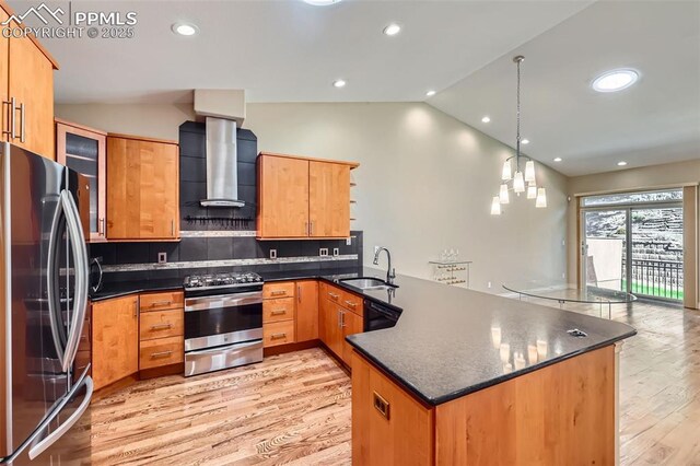 2252 Conservatory Pt, Colorado Springs, CO 80918 - kitchen with appliances with stainless steel finishes, lofted ceiling, a peninsula, wall chimney range hood, and light wood-style floors