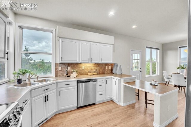 12572 Catch Pen Rd, Peyton, CO 80831 - kitchen featuring appliances with stainless steel finishes, light wood-style floors, backsplash, white cabinets, and recessed lighting