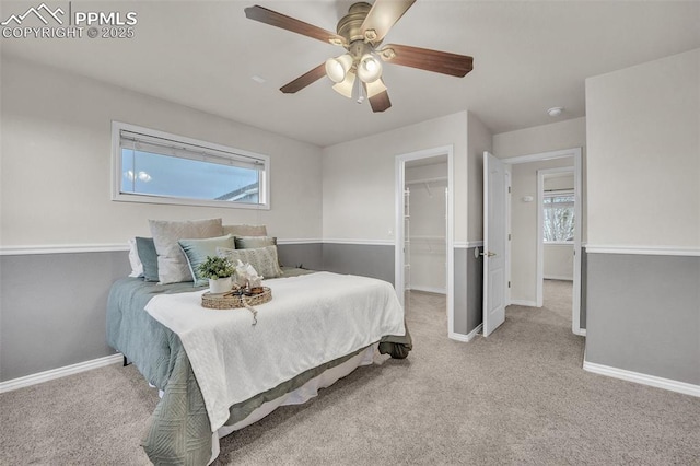 12572 Catch Pen Rd, Peyton, CO 80831 - carpeted bedroom with multiple windows, baseboards, a walk in closet, and a ceiling fan