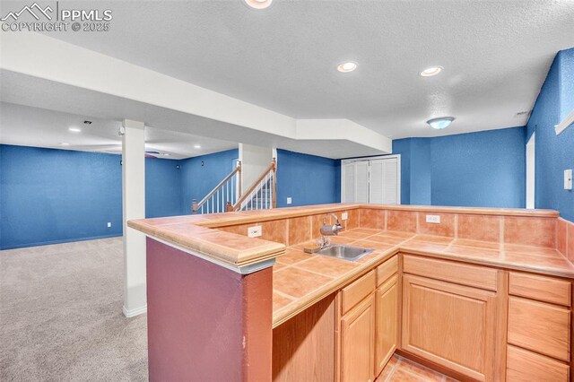 12572 Catch Pen Rd, Peyton, CO 80831 - kitchen featuring tile countertops, a sink, light colored carpet, recessed lighting, and a textured ceiling