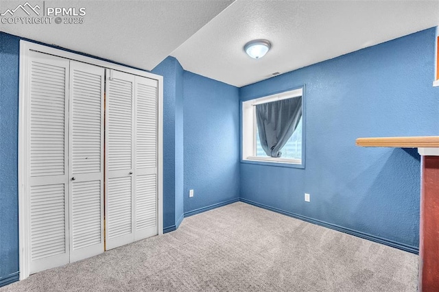 12572 Catch Pen Rd, Peyton, CO 80831 - unfurnished bedroom with a textured wall, carpet flooring, a textured ceiling, a closet, and baseboards