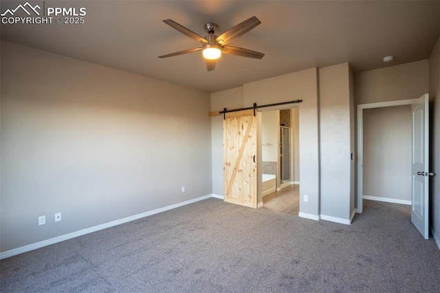 1985 Reed Grass Way, Colorado Springs, CO 80915 - unfurnished bedroom with a barn door, baseboards, carpet floors, a ceiling fan, and ensuite bathroom
