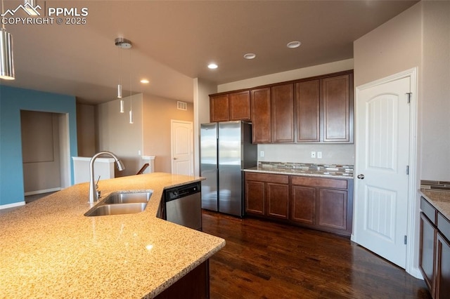 1985 Reed Grass Way, Colorado Springs, CO 80915 - kitchen featuring appliances with stainless steel finishes, a sink, light stone counters, dark wood-style flooring, and decorative light fixtures