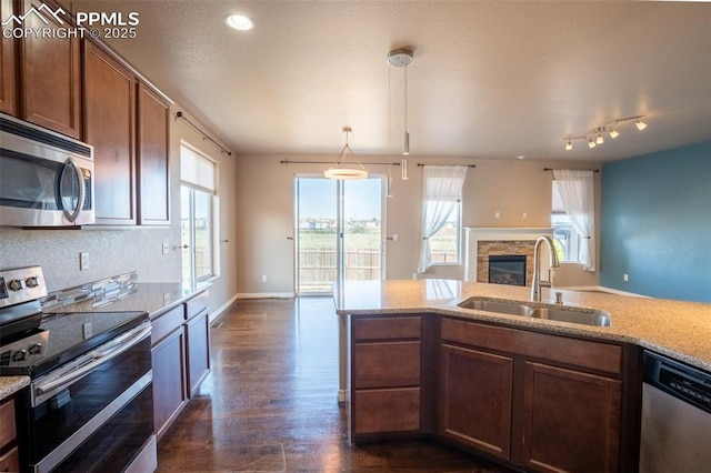1985 Reed Grass Way, Colorado Springs, CO 80915 - kitchen featuring stainless steel appliances, a sink, a fireplace, plenty of natural light, and recessed lighting