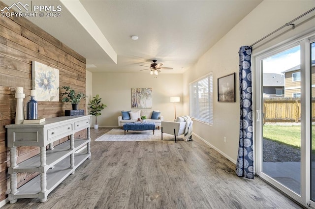 7923 Wagonwood Pl, Colorado Springs, CO 80908 - sitting room with wood finished floors, a ceiling fan, wooden walls, and baseboards