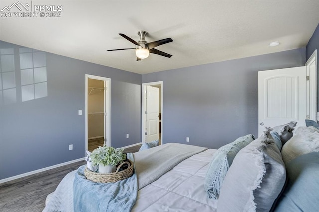 7923 Wagonwood Pl, Colorado Springs, CO 80908 - bedroom with wood finished floors, a spacious closet, baseboards, a ceiling fan, and a closet