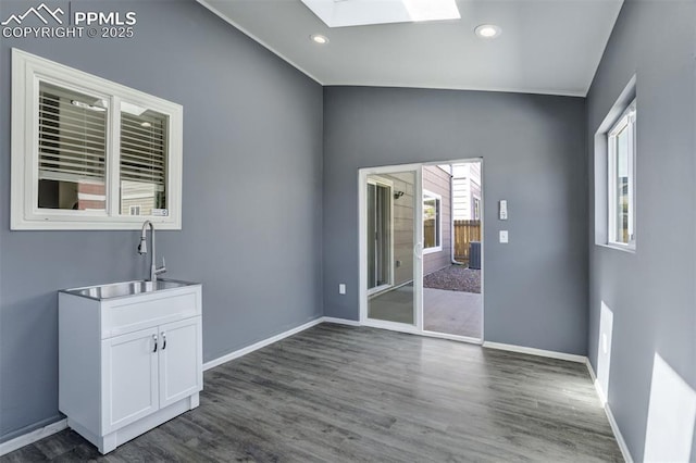 7923 Wagonwood Pl, Colorado Springs, CO 80908 - unfurnished room with a skylight, lofted ceiling, a sink, dark wood-style flooring, and recessed lighting