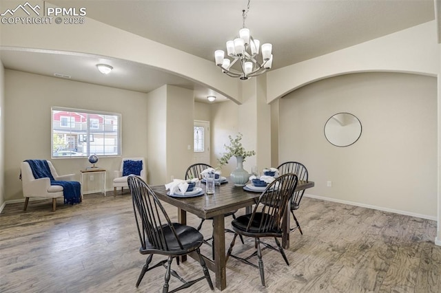7923 Wagonwood Pl, Colorado Springs, CO 80908 - dining room featuring arched walkways, a chandelier, light wood-style floors, and baseboards